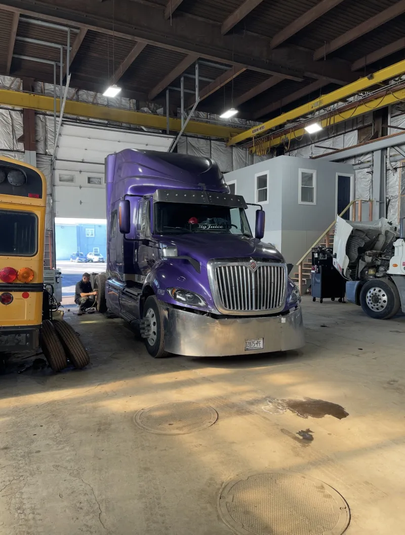 Purple commercial truck in the Top Guns repair bay.