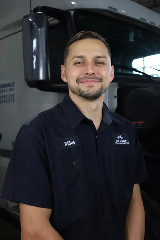 Mike, shop foreman at Top Guns, standing in front of a white Volvo.