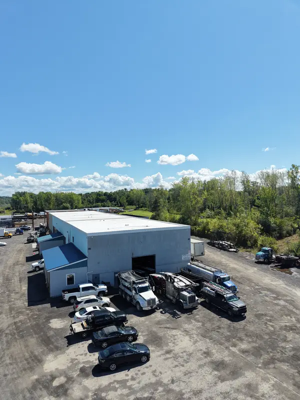 Aerial looking down on the open bay door with dump and tractor trucks parked in front.