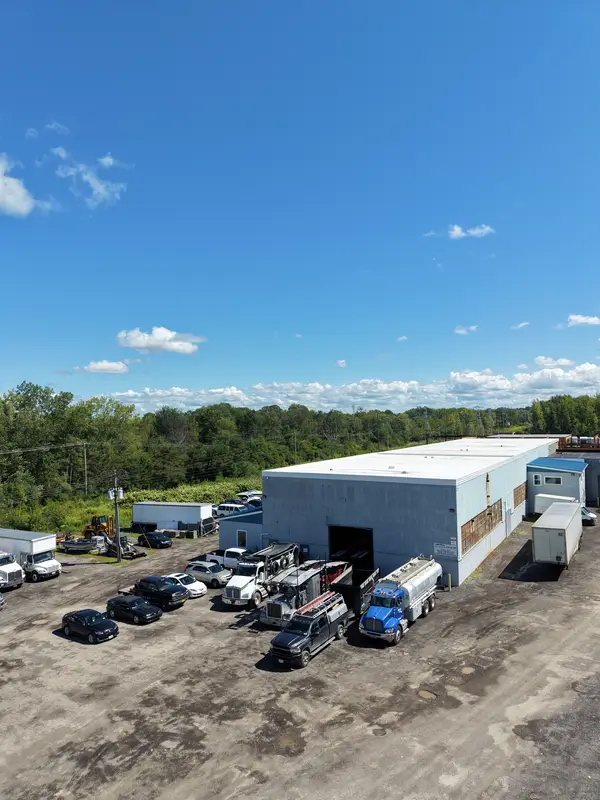 Aerial of the shop lot with a blue tanker and other commercial trucks parked at the building.