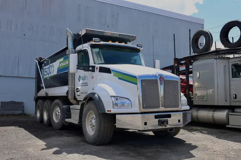 White Kenworth dump truck parked in the Top Guns lot.